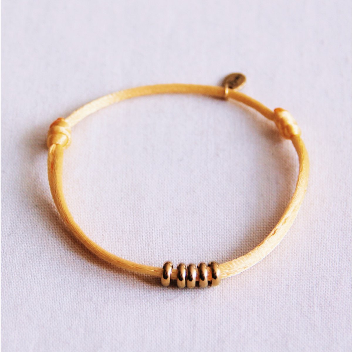 Satijnen armband met ringen – geel/goud